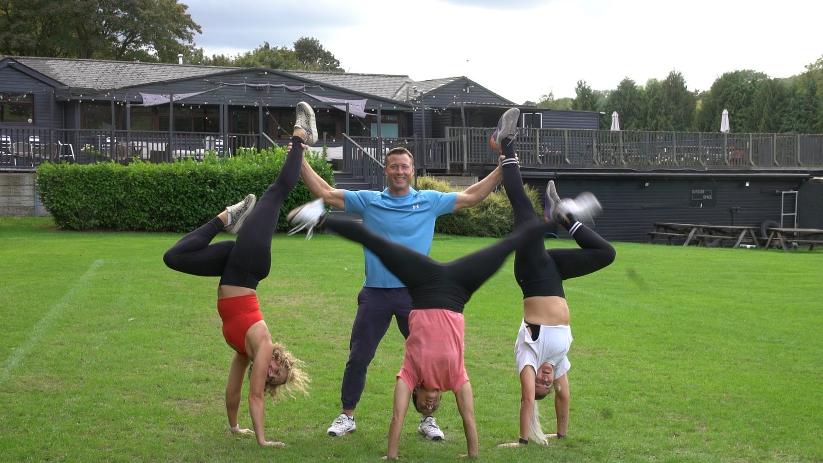 The Magnolia Park coaches together on the grounds, James holding two of them in handstands